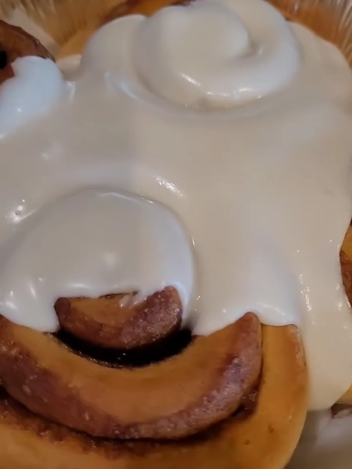 Freshly glazed cinnamon rolls in a baking pan